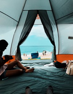 Girl in camping tent by the beach