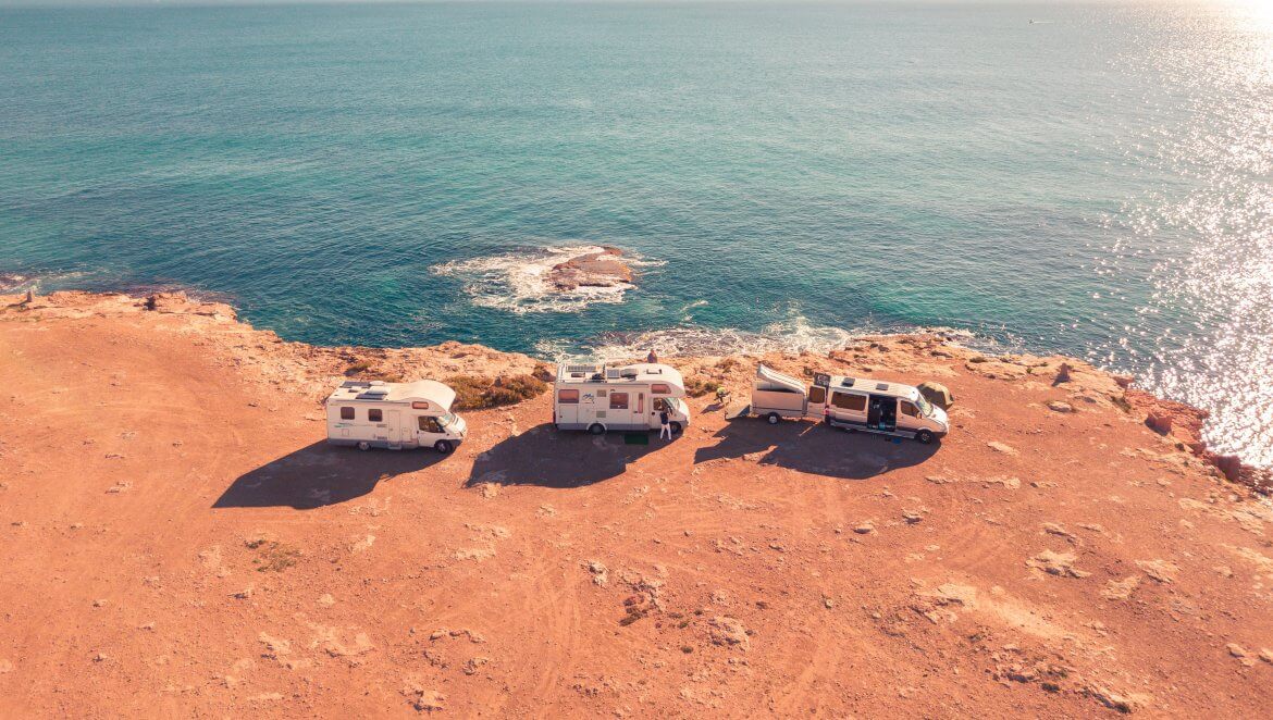 three motorhomes driving along coastline